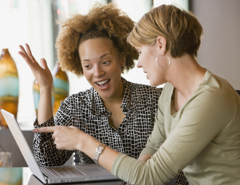 Multi-ethnic businesswomen looking at laptop